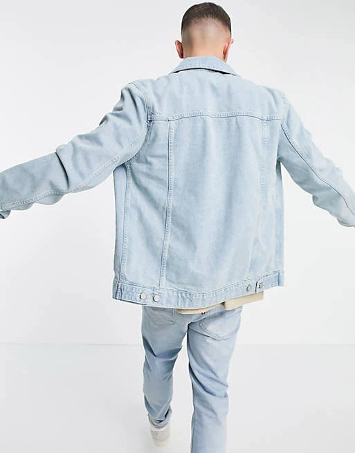 Back view of men's light blue denim jacket